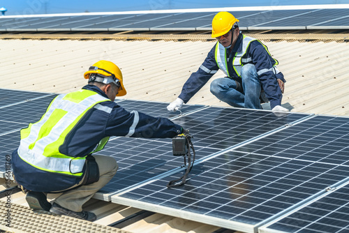 Wallpaper Mural engineer men inspects construction of solar cell panel or photovoltaic cell at roof top. Industrial Renewable energy of green power. factory at urban area. worker working on tower roof. Torontodigital.ca