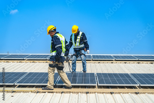 Worker Technicians are working to construct solar panels system on roof with sky and clound on background. Installing solar photovoltaic panel system. Renewable clean energy technology concept. © ultramansk