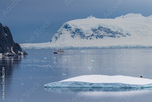 Danco Island, Antarctic Peninsula - January 31, 2024. Outlook over the Antarctic waters near Danco island, while tourist cruise around in Zodiacs and an Antarctic cruise ship passes by.