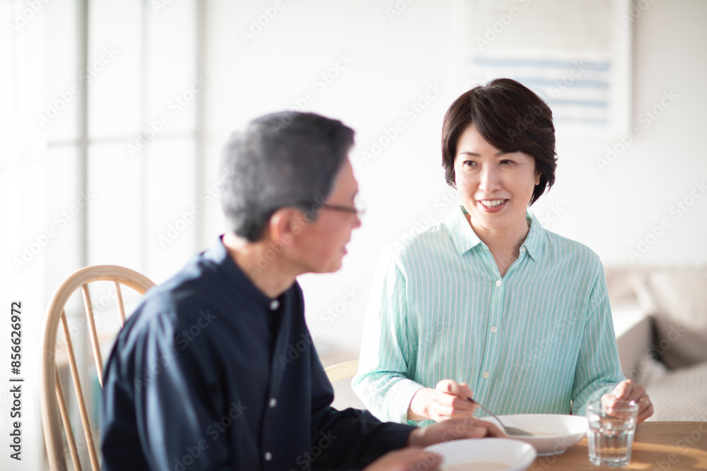 リビングで食事を楽しむシニア夫婦 リビングで食事を楽しむシニア夫婦