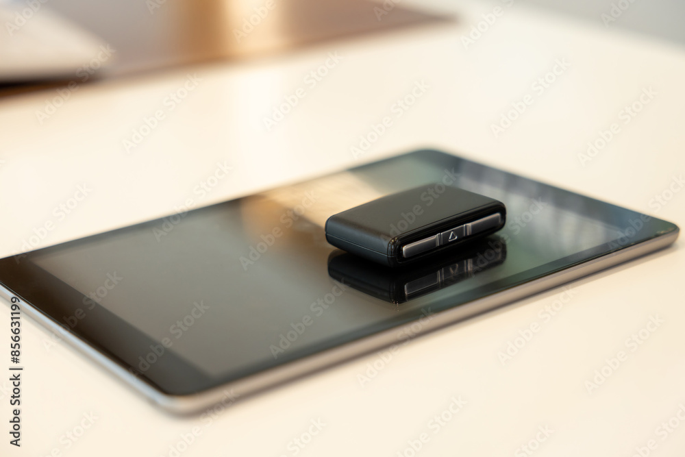 Tablet and car keys laying on the table Tablet and car keys laying on the table