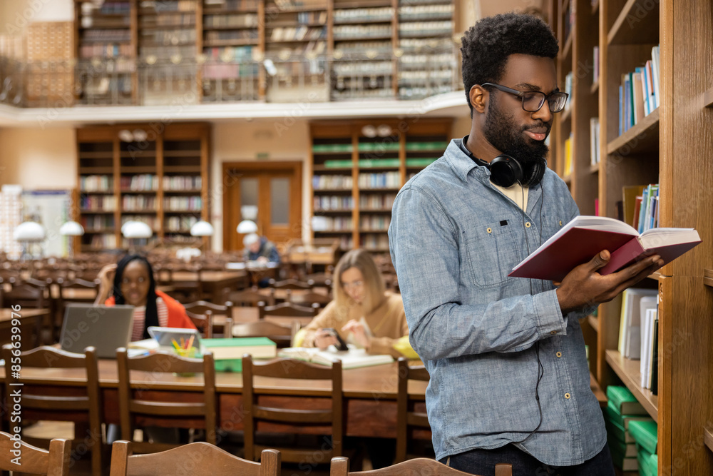 African american young man in the library looking busy and involved African american young man in the library looking busy and involved