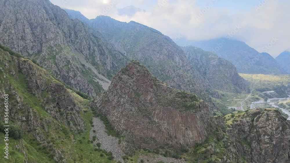 A dramatic view of a rocky mountain range with steep cliffs and rugged terrain. The sky is clear, highlighting the sharp features of the mountains and their natural beauty. A dramatic view of a rocky mountain range with steep cliffs and rugged terrain. The sky is clear, highlighting the sharp features of the mountains and their natural beauty.