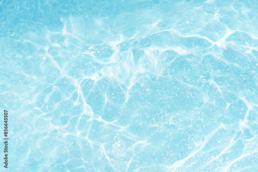 Blue water with ripples on the surface. Defocus blurred transparent blue colored clear calm water surface texture with splashes and bubbles. Water waves with shining pattern texture background. Blue water with ripples on the surface. Defocus blurred transparent blue colored clear calm water surface texture with splashes and bubbles. Water waves with shining pattern texture background.