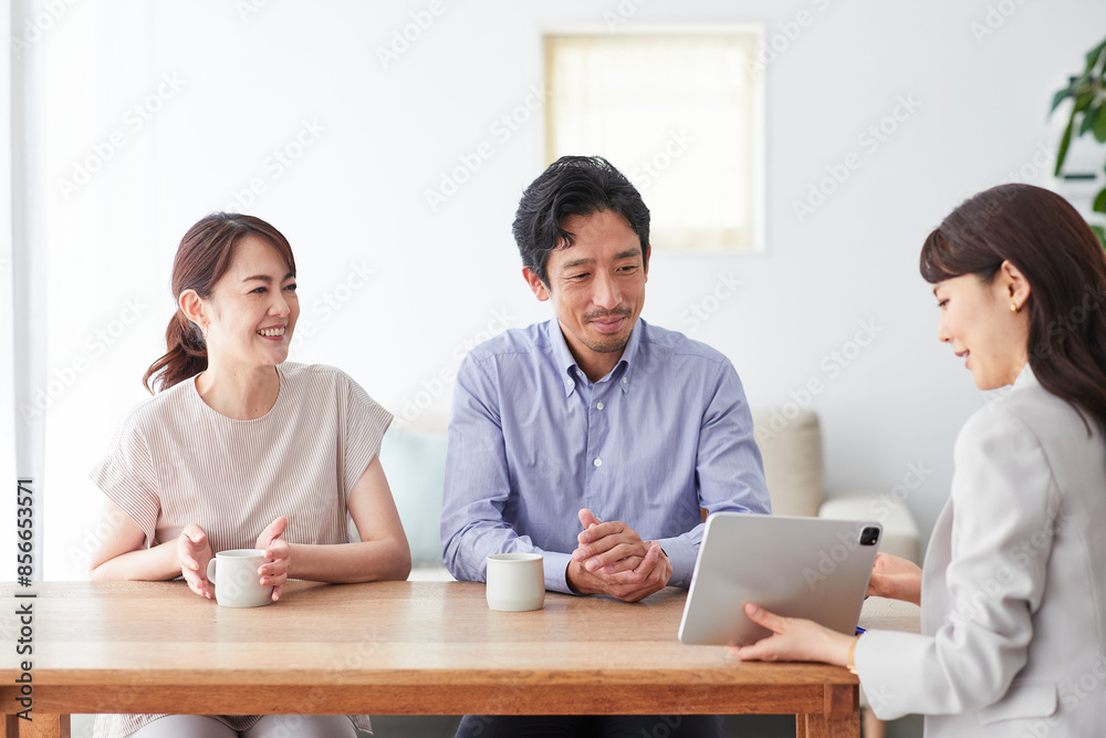 スーツを着てタブレット端末を持つ女性と夫婦 スーツを着てタブレット端末を持つ女性と夫婦