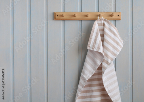 striped cotton towel hangs on a wooden hanger in the white kitchen. eco-friendly interior without plastic. copy space.