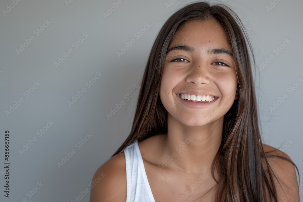 Portrait of beautiful smiling young hispanic woman with long straight hair, looking at camera isolated on white background. Portrait of happy latin girl wearing tank top laughing and showing perfect t Portrait of beautiful smiling young hispanic woman with long straight hair, looking at camera isolated on white background. Portrait of happy latin girl wearing tank top laughing and showing perfect t