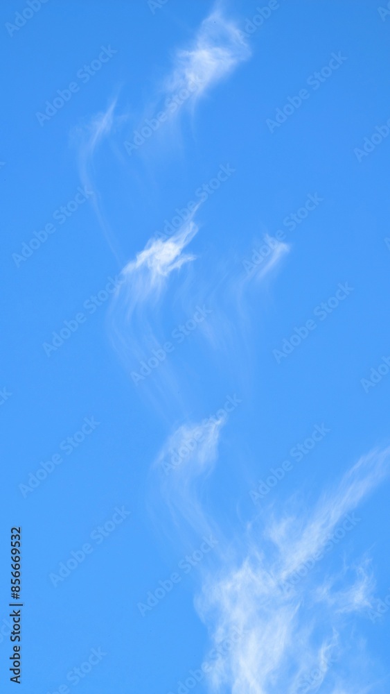 Clear blue sky with unusual white clouds, nature background, painted sky, natural template