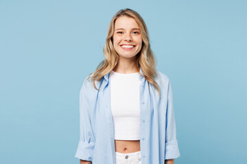 Young smiling happy cheerful fun satisfied cool woman she wearing white top shirt casual clothes looking camera isolated on plain pastel light blue cyan background studio portrait. Lifestyle concept.