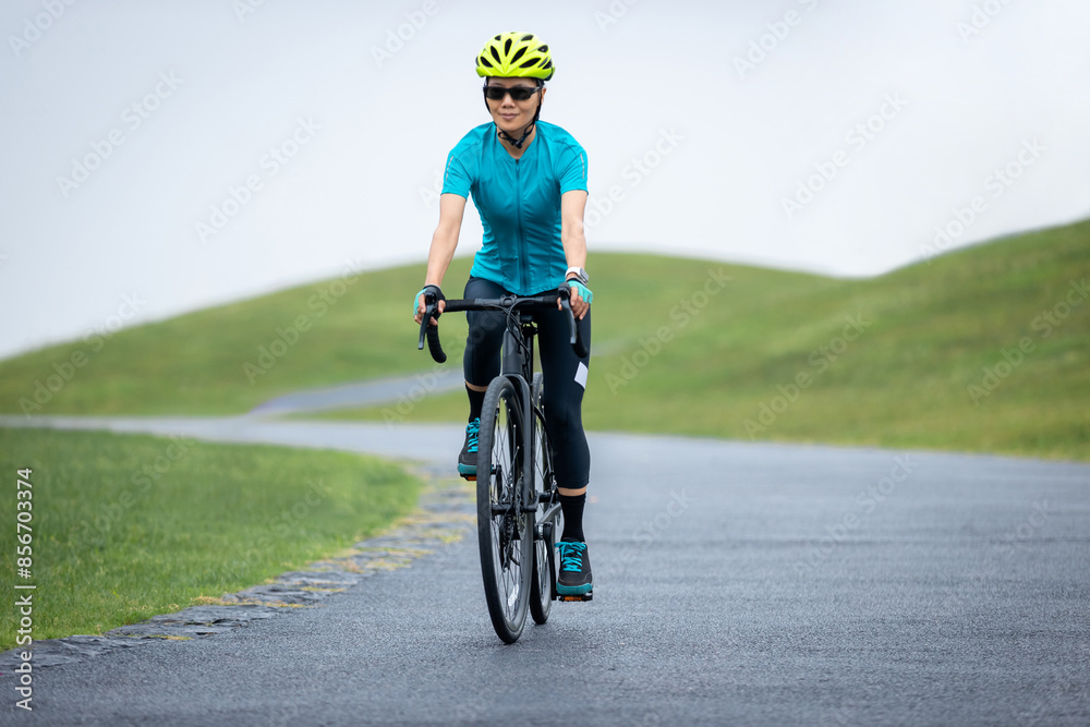 Fototapeta premium Woman biking on summer mountain trail