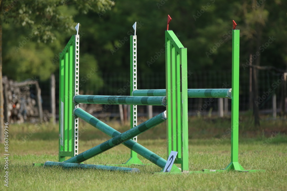 Fototapeta premium Horse obstacle course outdoors summertime. Poles in the sand for equestrian event