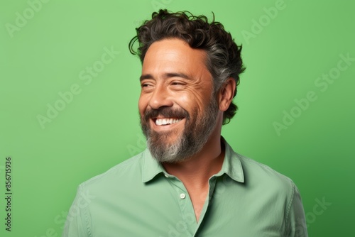 Happy Hispanic man, 35 years old, winking on a pastel green background