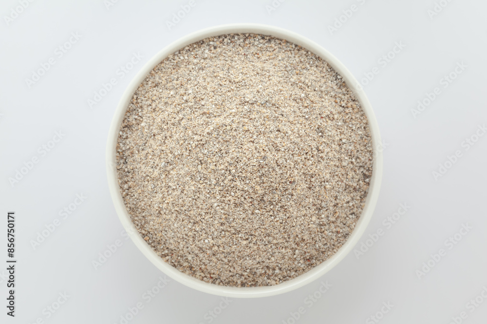 Organic Pearl Millet Flour (Pennisetum glaucum) or Bajra Flour, in a white ceramic bowl. Isolated on a gray background. Top View