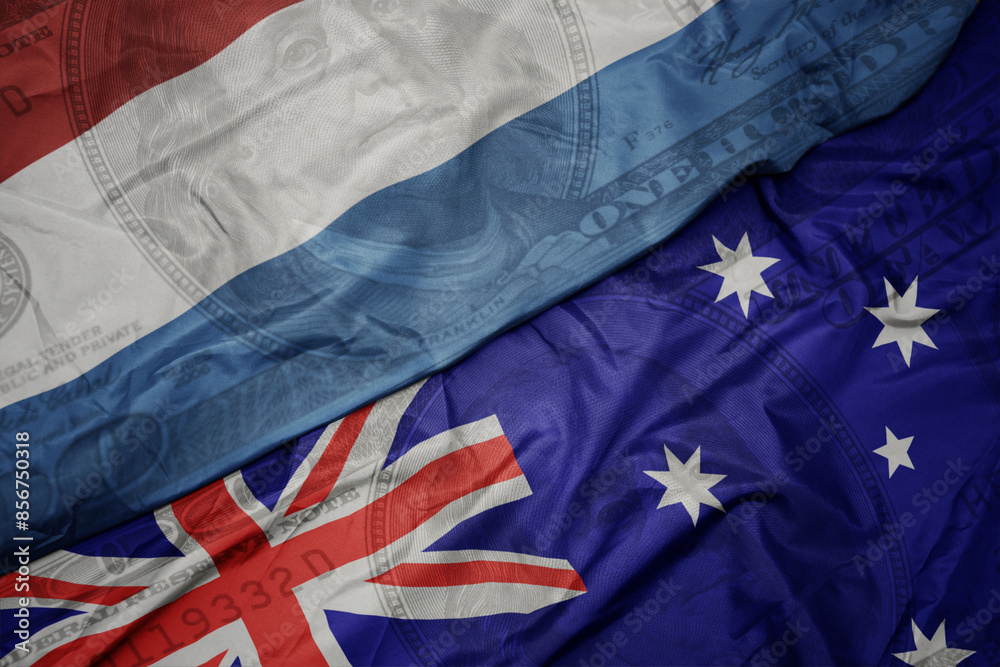 waving colorful flag of luxembourg and national flag of australia on the dollar money background. finance concept. waving colorful flag of luxembourg and national flag of australia on the dollar money background. finance concept.