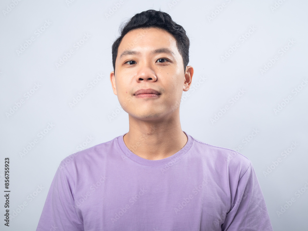 Young Asian man in a lavender t-shirt smiling warmly at the camera. Studio shot on a plain background, highlighting his cheerful expression and casual fashion. Young Asian man in a lavender t-shirt smiling warmly at the camera. Studio shot on a plain background, highlighting his cheerful expression and casual fashion.