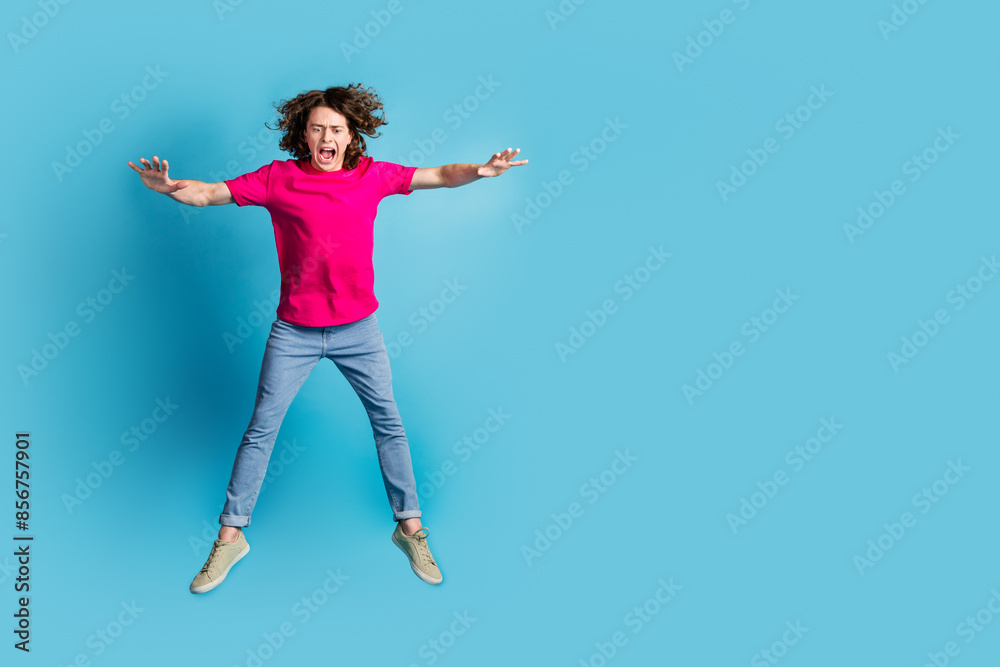 Full size photo of nice young man jump fall empty space wear t-shirt isolated on blue color background Full size photo of nice young man jump fall empty space wear t-shirt isolated on blue color background