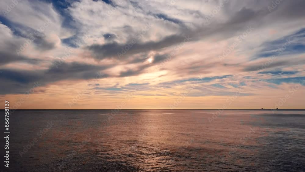 Time Lapse of sun rises over the Mediterranean Sea, sending rays of light across the water's surface and piercing mass of thick clouds Time Lapse of sun rises over the Mediterranean Sea, sending rays of light across the water's surface and piercing mass of thick clouds