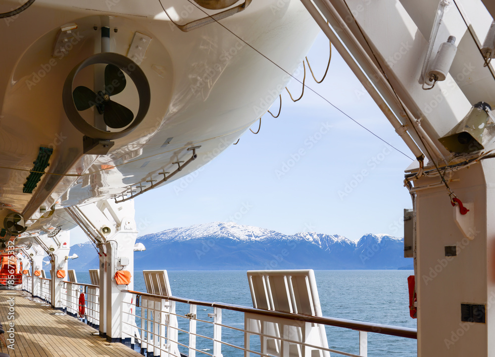 Bottom view of lifeboat mounted on a large cruise ship. Snow Capped mountains in the distance. Alaska.