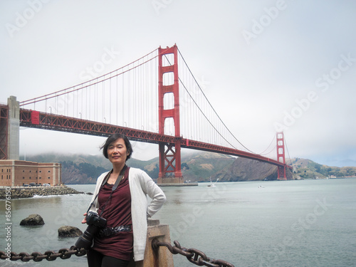 Photography Female tourist with a big camera posing for photos in front of the Golden Gate Bridge