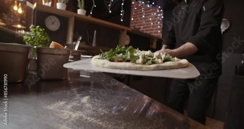 Pizza chef puts the pizza in the oven with an open flame, Neapolitan pizza