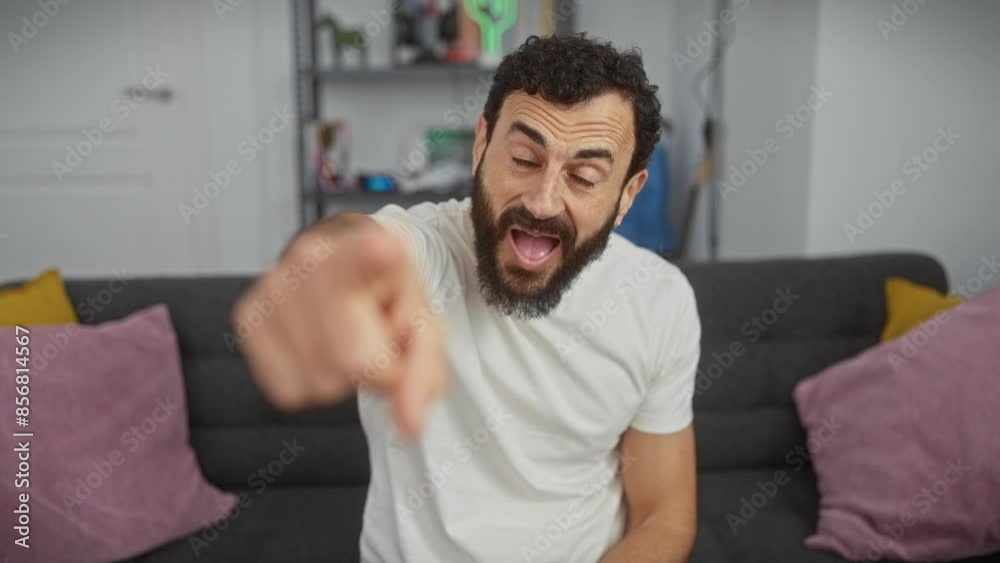 Furious middle age man in white t shirt angrily pointing at you through camera, utterly frustrated and displeased; indoors expressing raw emotion at home. Furious middle age man in white t shirt angrily pointing at you through camera, utterly frustrated and displeased; indoors expressing raw emotion at home.
