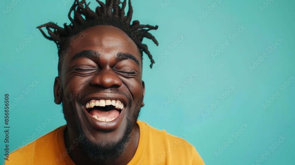 A man with dreadlocks laughs while looking at the camera A man with dreadlocks laughs while looking at the camera
