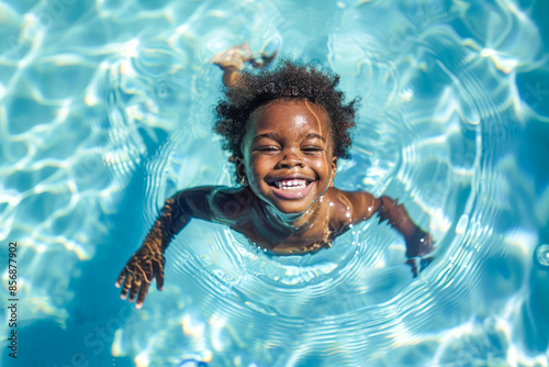 Happy young boy learning to swim in pool on summer vacation