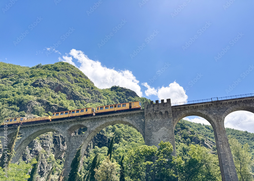 The yellow train (Le Petit Train Jaune) en route in Occitanie, Pyrénées Orientales. The yellow train (Le Petit Train Jaune) en route in Occitanie, Pyrénées Orientales.