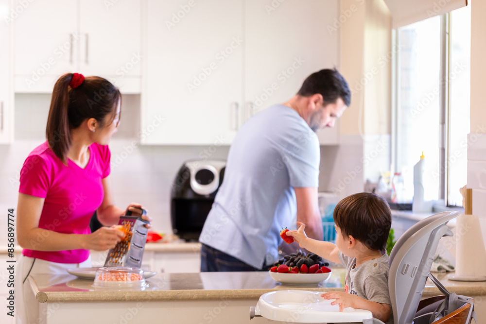 Family doing chores together in kitchen at home mum preparing food and dad washing up in sink Family doing chores together in kitchen at home mum preparing food and dad washing up in sink