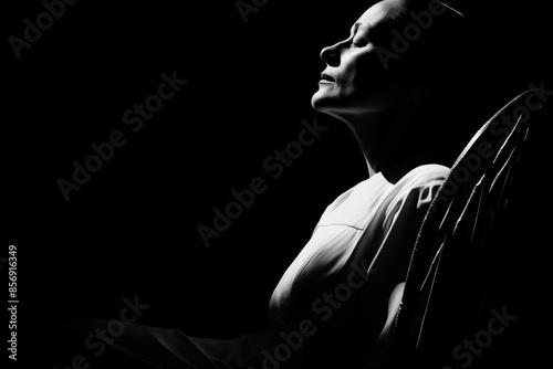 A black and white photo of a woman in a rocking chair, conveying a sense of peace and tranquility. 