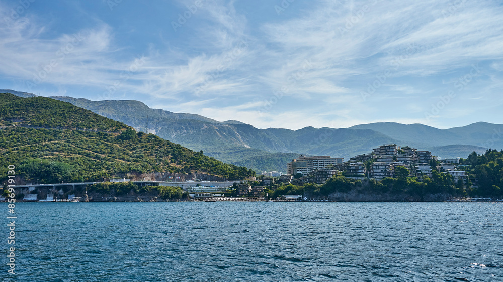 Marvelous seaside landscape with mountains and gentle clouds in the blue sky Marvelous seaside landscape with mountains and gentle clouds in the blue sky