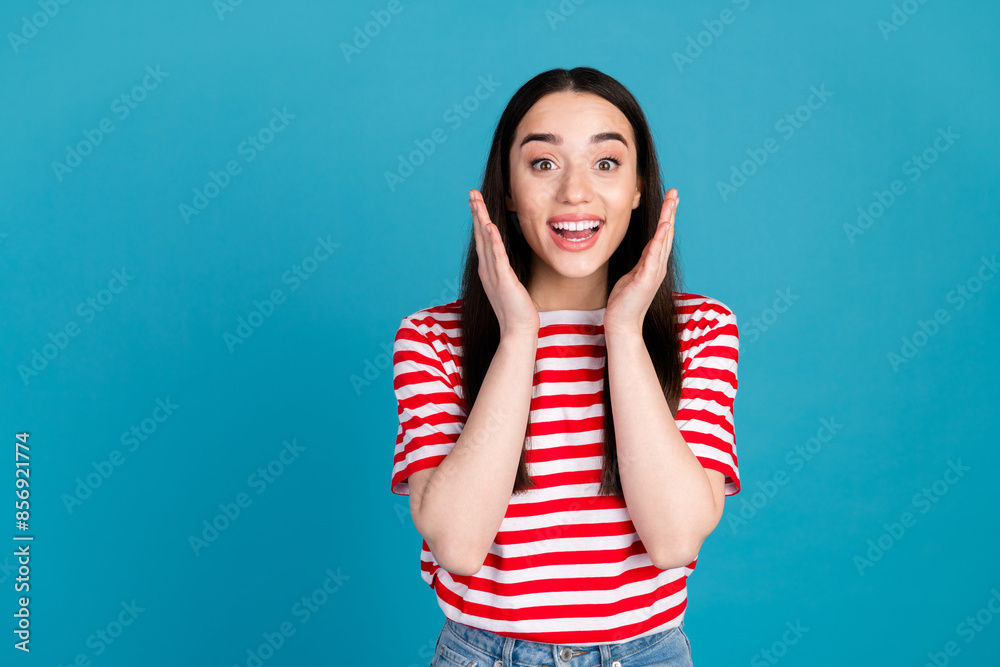 Photo of adorable impressed girl wear striped t-shirt smiling empty space isolated blue color background Photo of adorable impressed girl wear striped t-shirt smiling empty space isolated blue color background