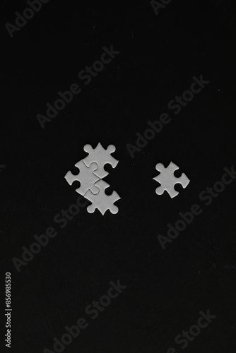 Solitary White Puzzle Pieces on Dark Background: Symbolizing Isolation and Incompletion photo