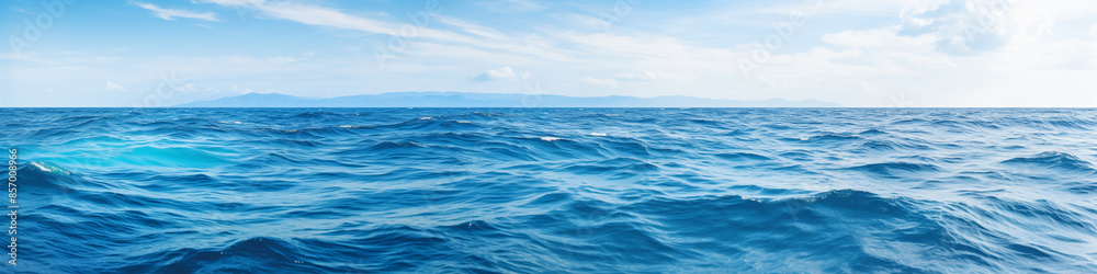 The ocean is calm and blue, with no visible waves The ocean is calm and blue, with no visible waves
