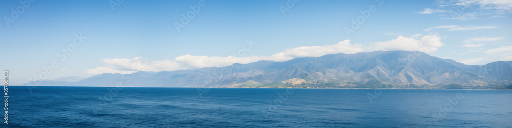 A beautiful blue ocean with mountains in the background A beautiful blue ocean with mountains in the background