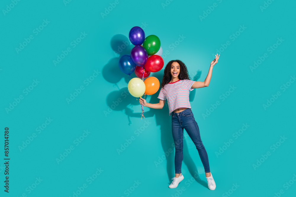 Full body photo of attractive young woman hold air balloons celebrate dressed striped clothes isolated on aquamarine color background