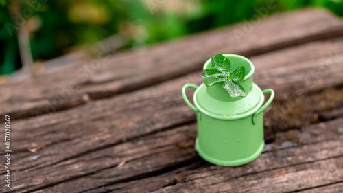 Four-leaf clover in green bucket in nature, symbol of good luck photo