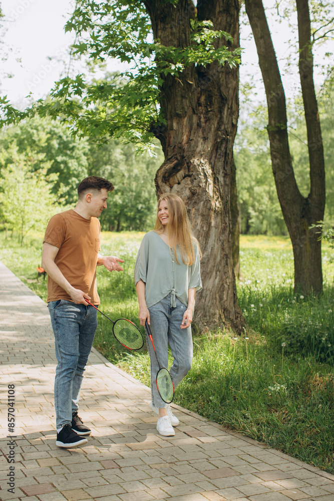 Happy young couple with badminton racquet together in park. Happy young couple with badminton racquet together in park.