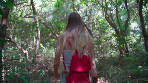 A young lady moves slowly through the forest, enjoying the surrounding nature.