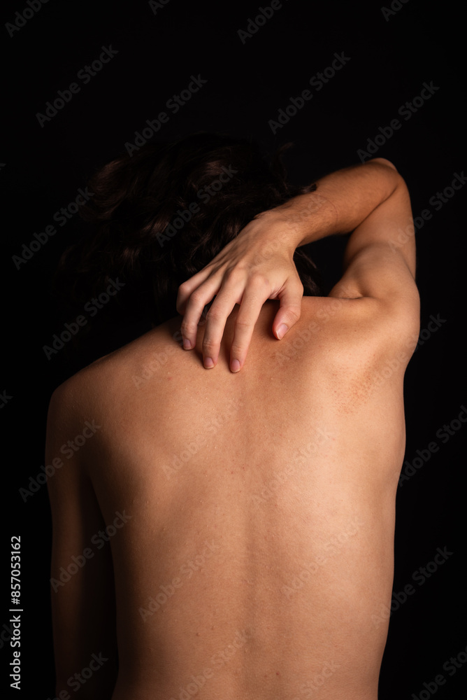 Young man, shirtless, scratching his back with his hands. Skin disease. Irritation, allergy. Young man, shirtless, scratching his back with his hands. Skin disease. Irritation, allergy.