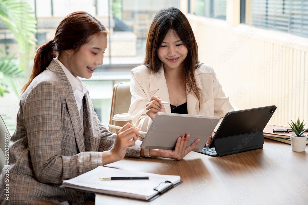 A charming Asian businesswoman or female office worker is having a meeting with her colleague in the meeting room, discussing work, and sharing her ideas. A charming Asian businesswoman or female office worker is having a meeting with her colleague in the meeting room, discussing work, and sharing her ideas.