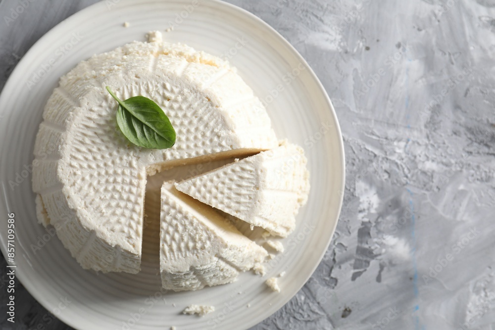 Tasty ricotta (cream cheese) on grey textured table, top view. Space for text Tasty ricotta (cream cheese) on grey textured table, top view. Space for text