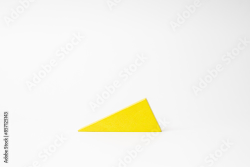 Colorful wooden toy block of yellow triangle against white background