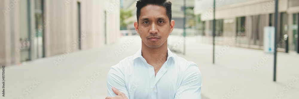Young businessman looking at camera while standing in business district Young businessman looking at camera while standing in business district