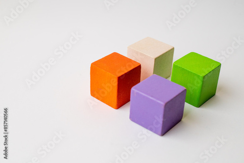 2x2 square of wooden toy cubes isolated on white background, negative space, diversity and variation concept, business concept