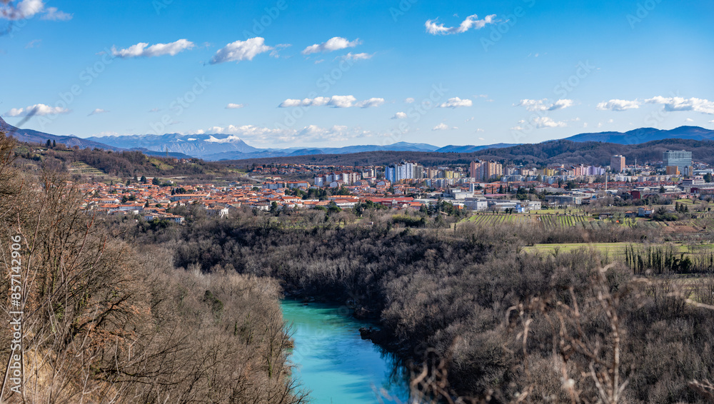 vista sulla città di Nova Gorica, nella Slovenia occidentale, in una vasta vallata, di giorno, in inverno, circondata da una vasta vegetazione, da lunghe colline, alture e montagne sotto un cielo blu