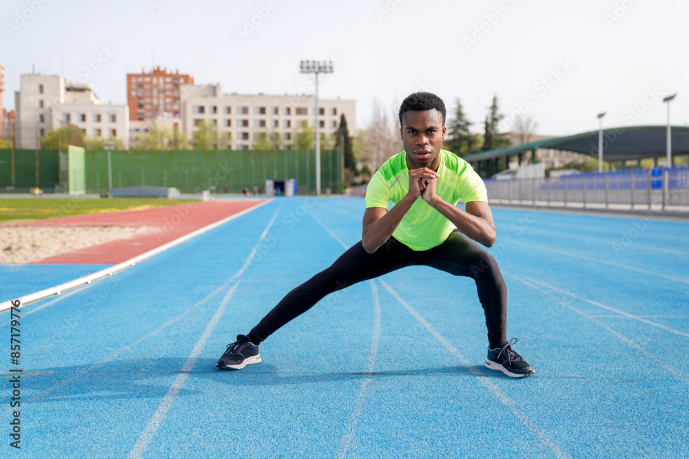 Fototapeta premium A african man is doing a workout on a track