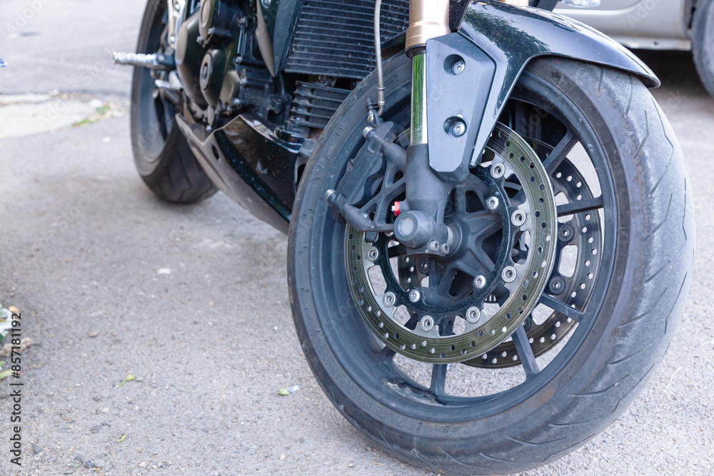 The front wheel of a powerful sports motorcycle, with a brake system and a fork.