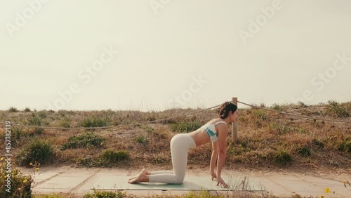 Portrait of a young woman doing yoga and stretching workout outdoors, video for yoga lessons and asanas guide photo