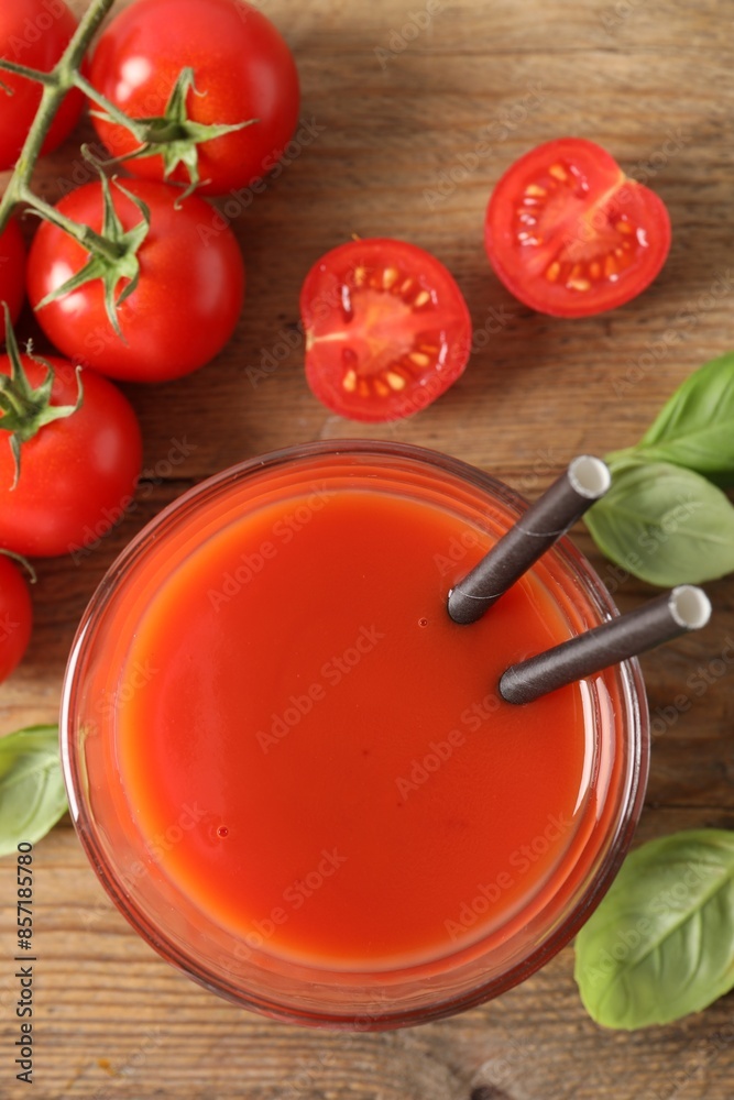 Tasty tomato juice in glass, basil leaves and fresh vegetables on wooden table, flat lay Tasty tomato juice in glass, basil leaves and fresh vegetables on wooden table, flat lay